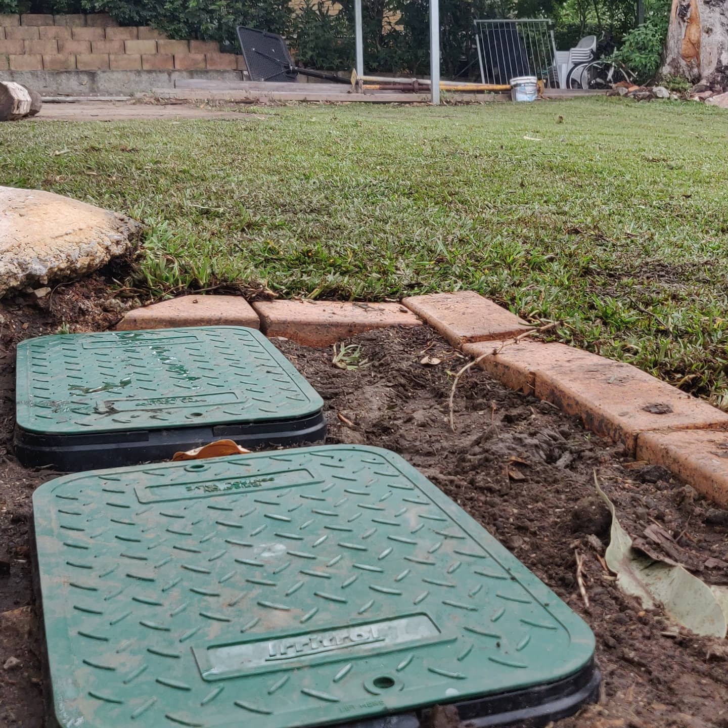 The transformation nears completion! Workers meticulously lay down rolls of fresh, green sod across the prepared ground. This new turf will soon become a beautiful green expanse, adding value and enjoyment to your property.